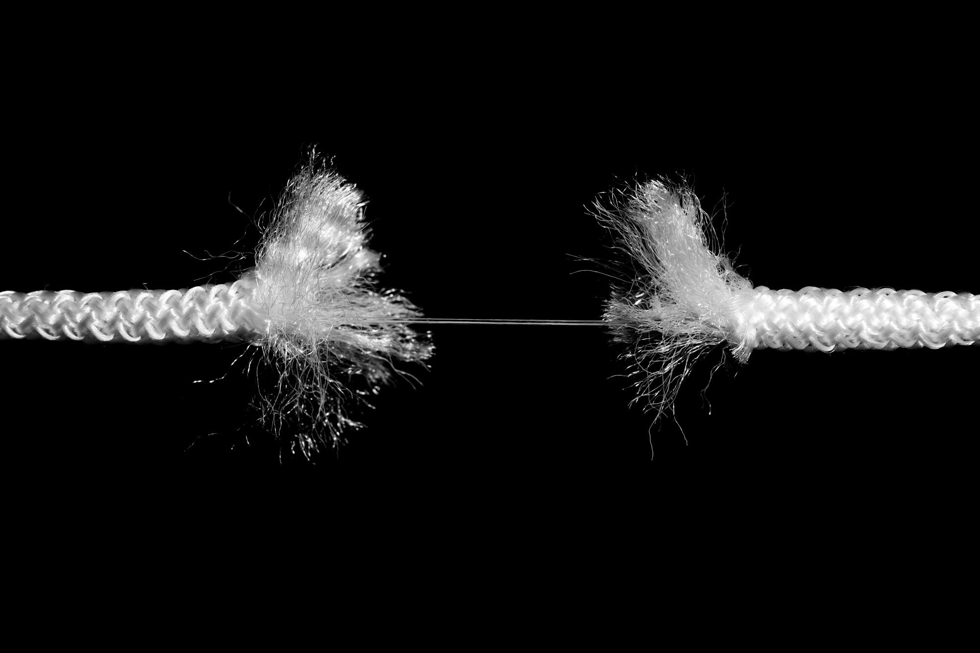 Rupture of white rope on black background